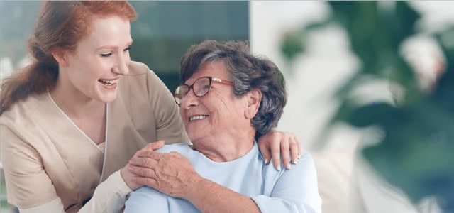 Caregiver smiling with elderly woman.