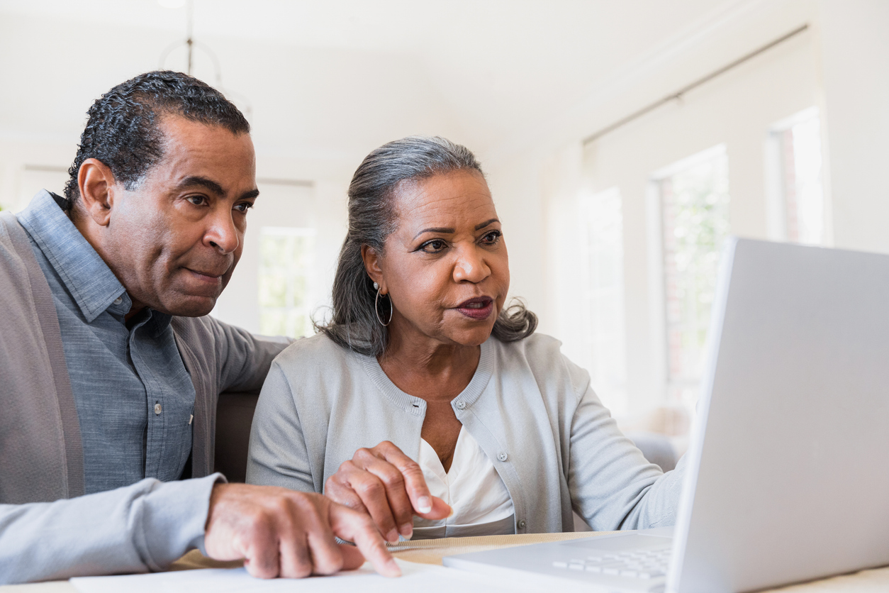 A senior man and woman looking at senior living options at Traditions of Deerfield on a laptop