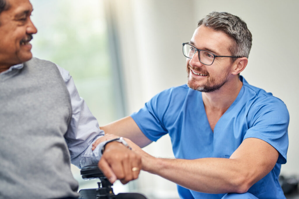 Male nurse talking with a memory care resident at Traditions of Deerfield in Loveland, OH.