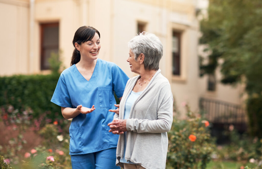 A nurse walking with a memory care resident at Traditions at Deerfield in Loveland, OH.