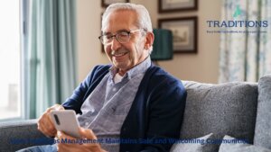 A senior man smiling and sitting on a blue couch with the Traditions Management logo in the top right corner of the image