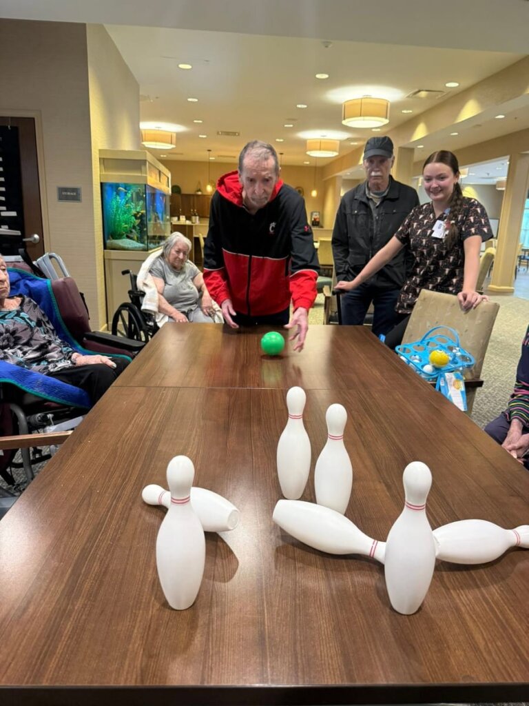 Residents participating in an indoor bowling activity at Traditions of Deerfield