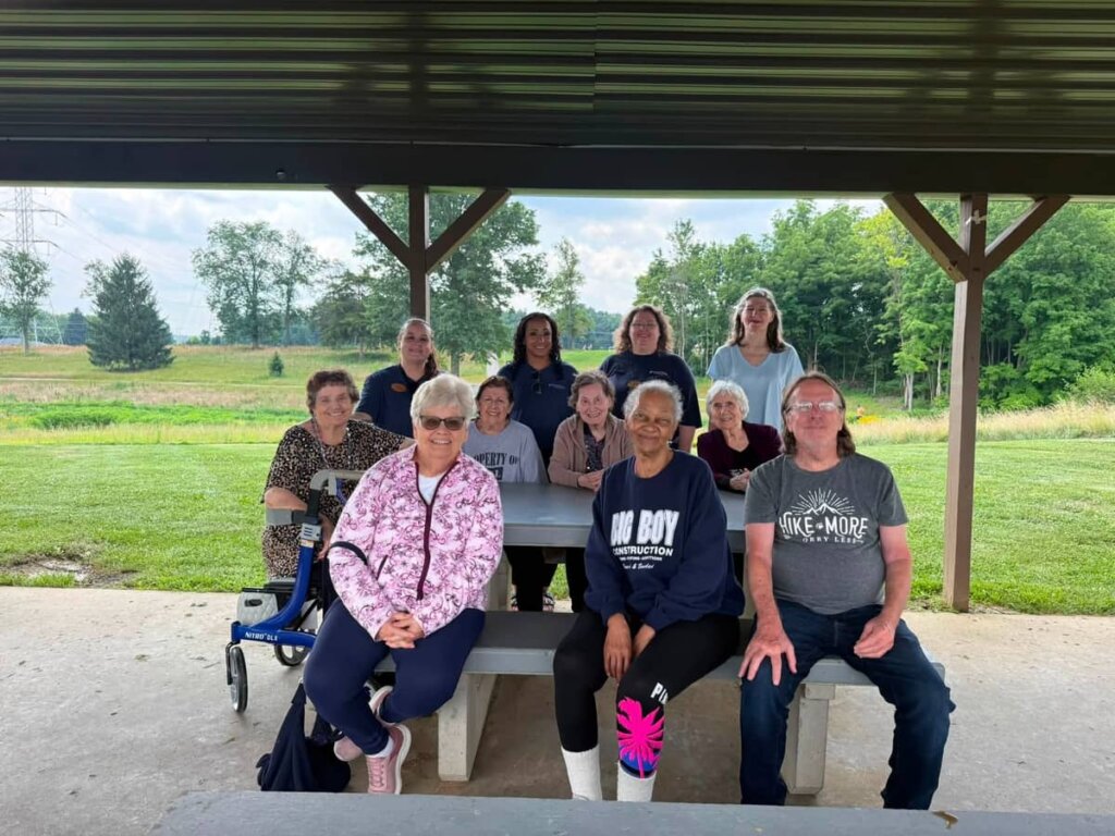 Residents and staff enjoying an outdoor group outing at Varietas Park near Traditions of Deerfield